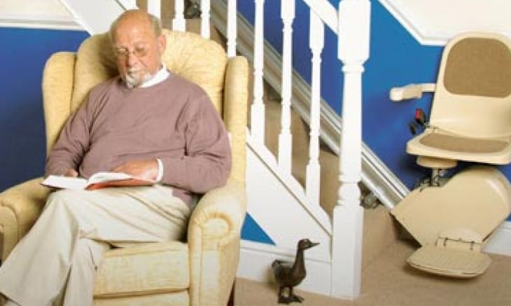 Man reading next to his stairlift